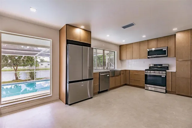 a kitchen with stainless steel appliances a refrigerator and a stove top oven