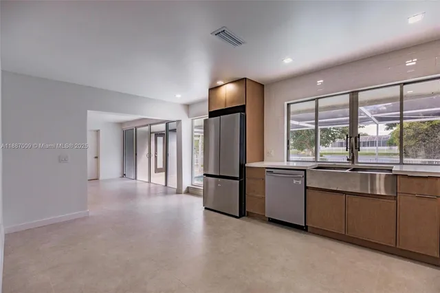 a large kitchen with a large window and refrigerator