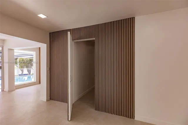 a view of a hallway with wooden floor and windows