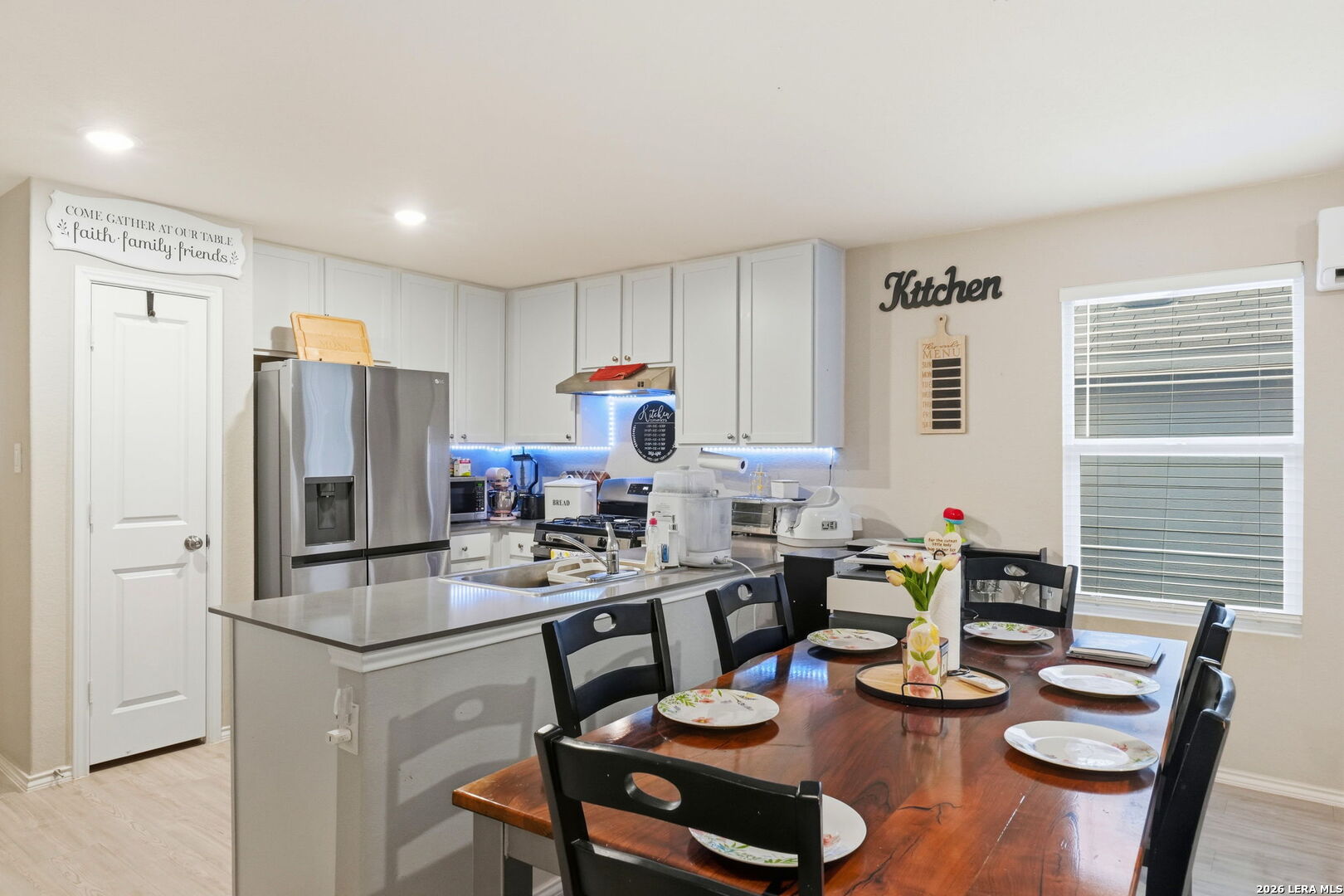 140 Maverick Cove Pleasanton, TX 78064 - Photo 8 of 26 a kitchen with sink refrigerator dining table and chairs