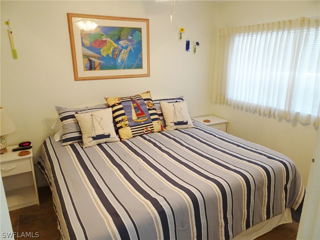 3215 Stringfellow Road, Unit 201 St. James City, FL 33956 - Photo 14 of 25 a bedroom with bed and a painting on the wall