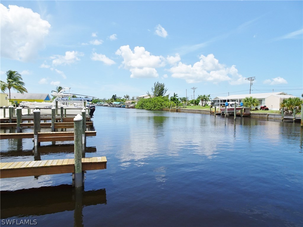 3215 Stringfellow Road, Unit 201 St. James City, FL 33956 - Photo 24 of 25 a lake view with boat and palm trees