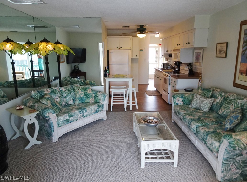 3215 Stringfellow Road, Unit 201 St. James City, FL 33956 - Photo 5 of 25 a living room with furniture and a kitchen