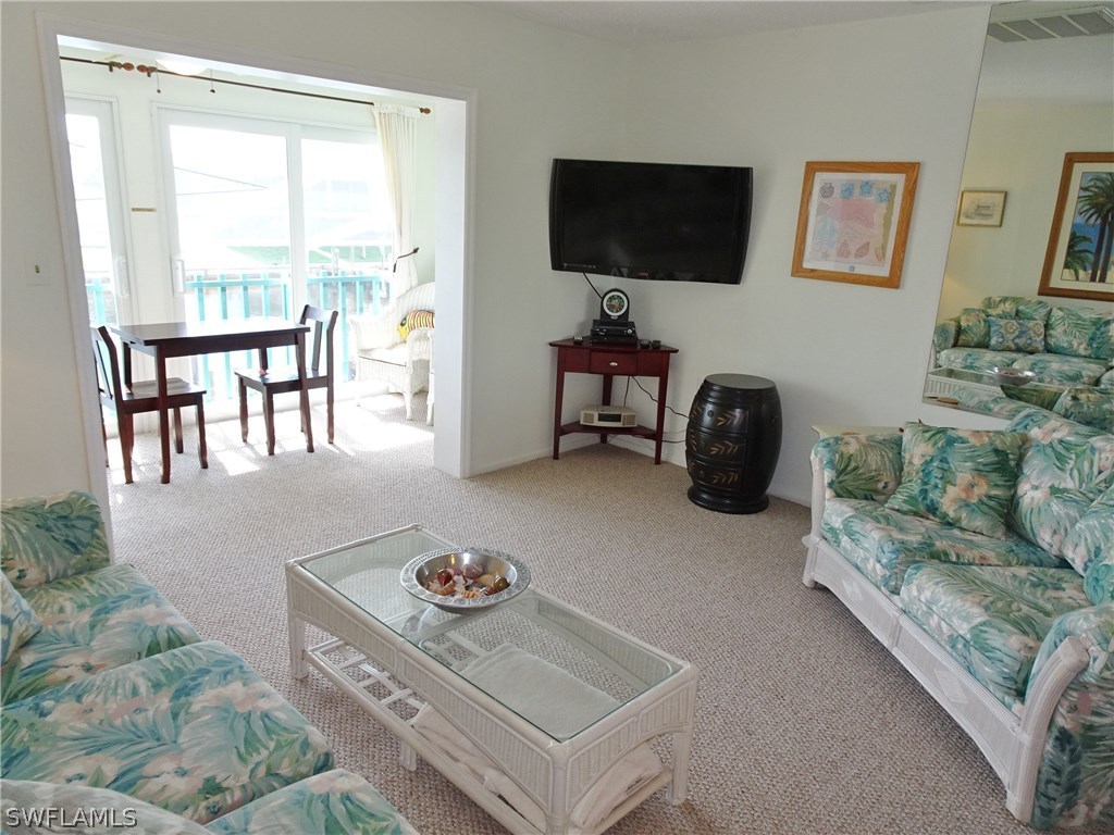 3215 Stringfellow Road, Unit 201 St. James City, FL 33956 - Photo 6 of 25 a living room with furniture and a flat screen tv