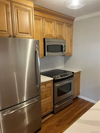 a kitchen with granite countertop stainless steel appliances and wooden cabinets