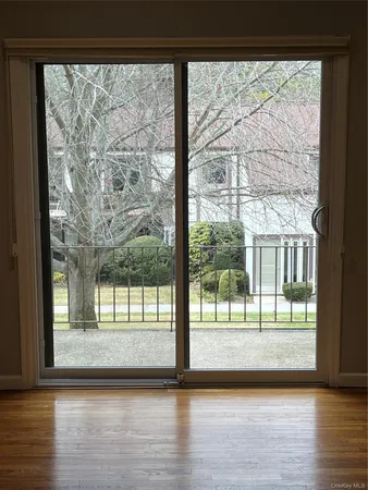 a view of empty room with wooden floor and floor to ceiling window