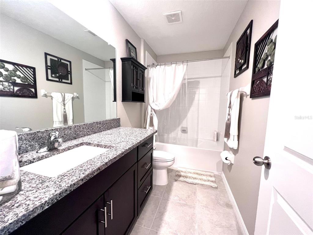 2170 Shining Azul Way Lutz, FL 33558 - Photo 10 of 16 a bathroom with a granite countertop sink a mirror and shower