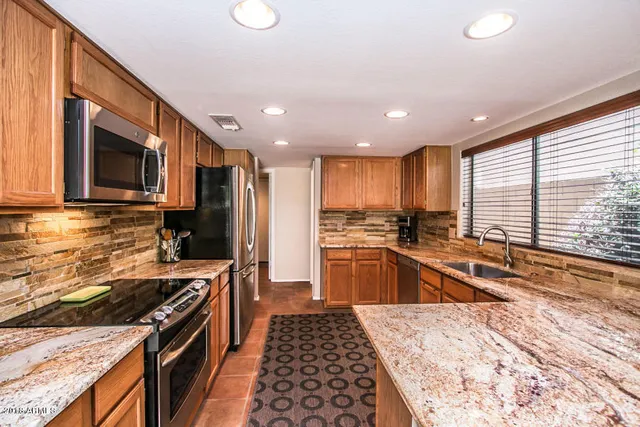 a kitchen with stainless steel appliances granite countertop a stove and a sink