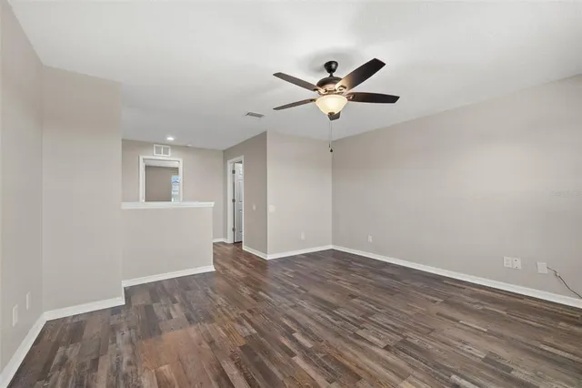 a view of empty room with wooden floor