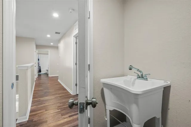 a view of a hallway with wooden floor and staircase