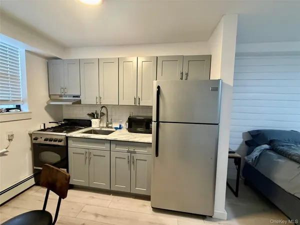 a kitchen with a refrigerator a sink and a stove top open