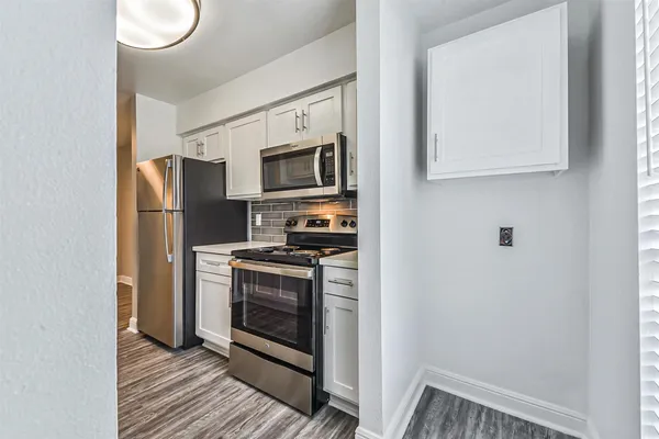 a kitchen with stainless steel appliances a stove a microwave and a refrigerator