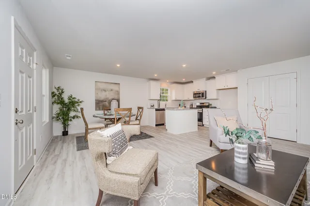 a living room with furniture kitchen and a potted plant