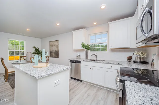 a kitchen with stainless steel appliances granite countertop a sink stove and cabinets