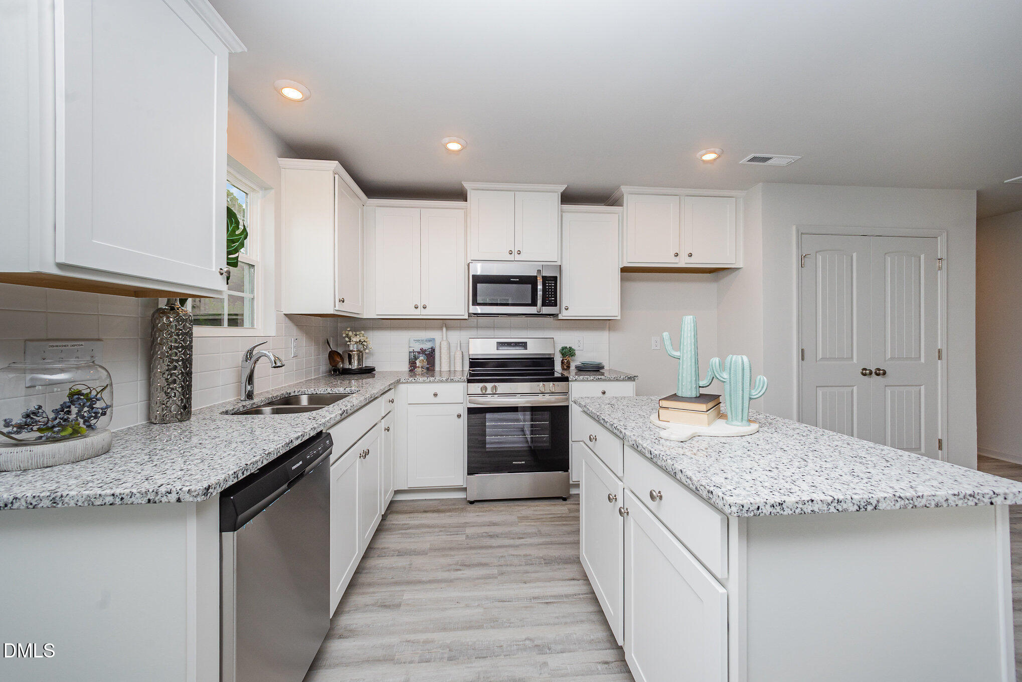 272 Johnson Rdg Way, Unit 1 Four Oaks, NC 27524 - Photo 15 of 27 a kitchen with granite countertop kitchen island sink stove and white cabinets