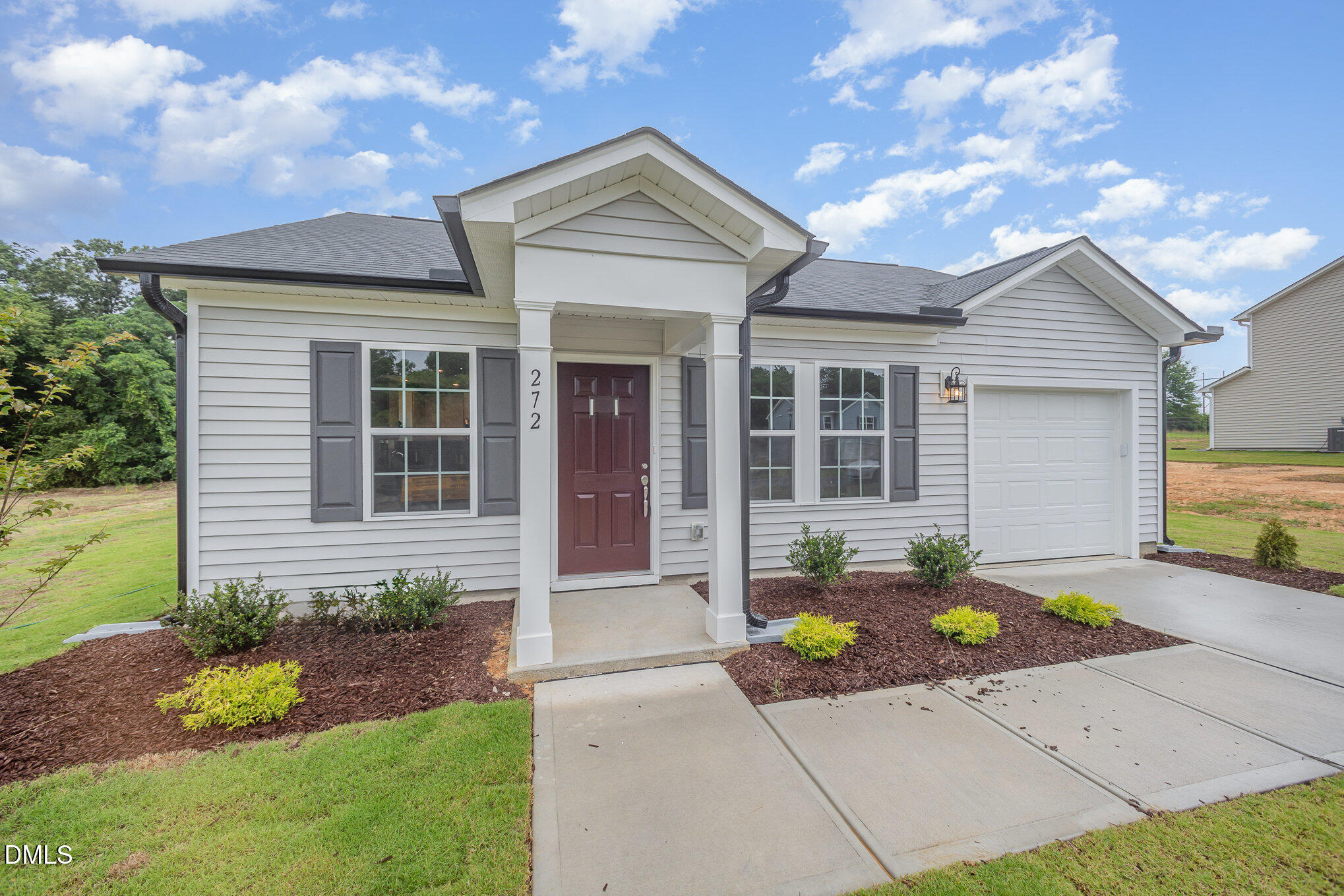 272 Johnson Rdg Way, Unit 1 Four Oaks, NC 27524 - Photo 2 of 27 a front view of a house with a garden and yard
