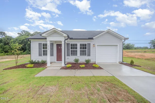a front view of a house with a garden and yard