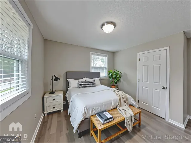 a bedroom with a bed and wooden floor