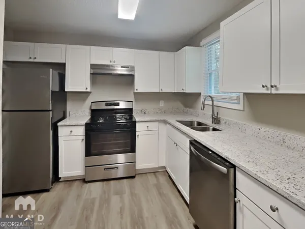 a kitchen with a sink and a stove top oven
