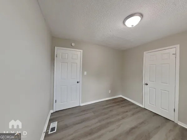 a view of an empty room and wooden floor