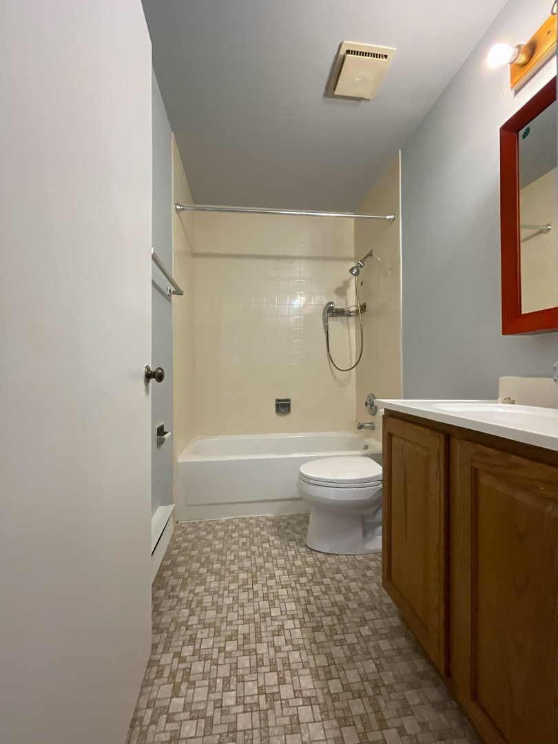 202 South Waters Edge Drive, Unit 201 Glendale Heights, IL 60139 - Photo 12 of 15 a bathroom with a toilet a window and shower