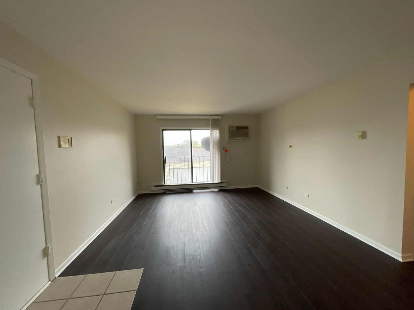 202 South Waters Edge Drive, Unit 201 Glendale Heights, IL 60139 - Photo 2 of 15 an empty room with wooden floor and windows
