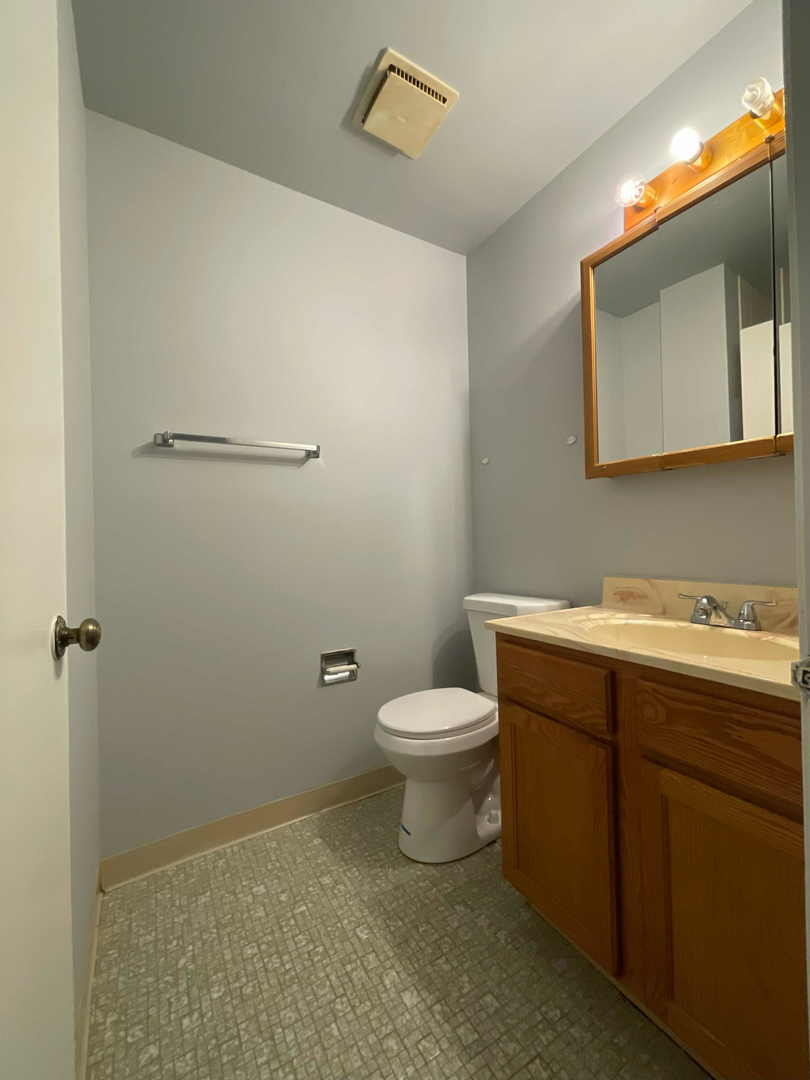 202 South Waters Edge Drive, Unit 201 Glendale Heights, IL 60139 - Photo 8 of 15 a bathroom with a toilet a sink and mirror