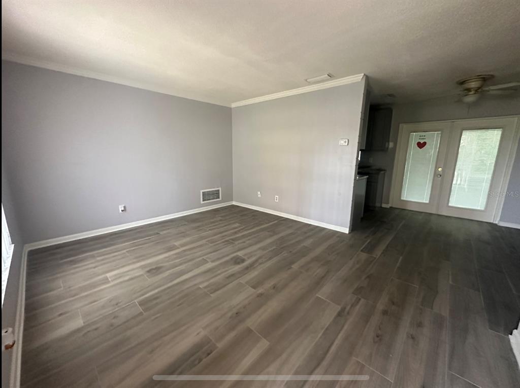 2906 Garden Road Eustis, FL 32726 - Photo 2 of 12 an empty room with wooden floor and windows