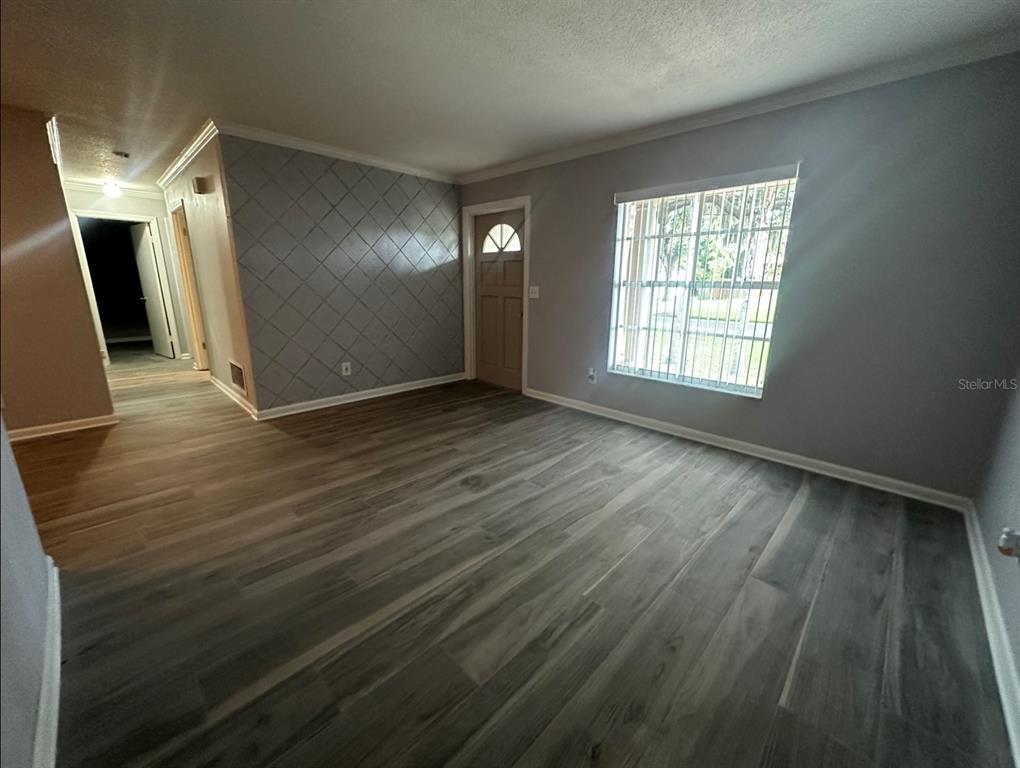2906 Garden Road Eustis, FL 32726 - Photo 3 of 12 an empty room with wooden floor and windows