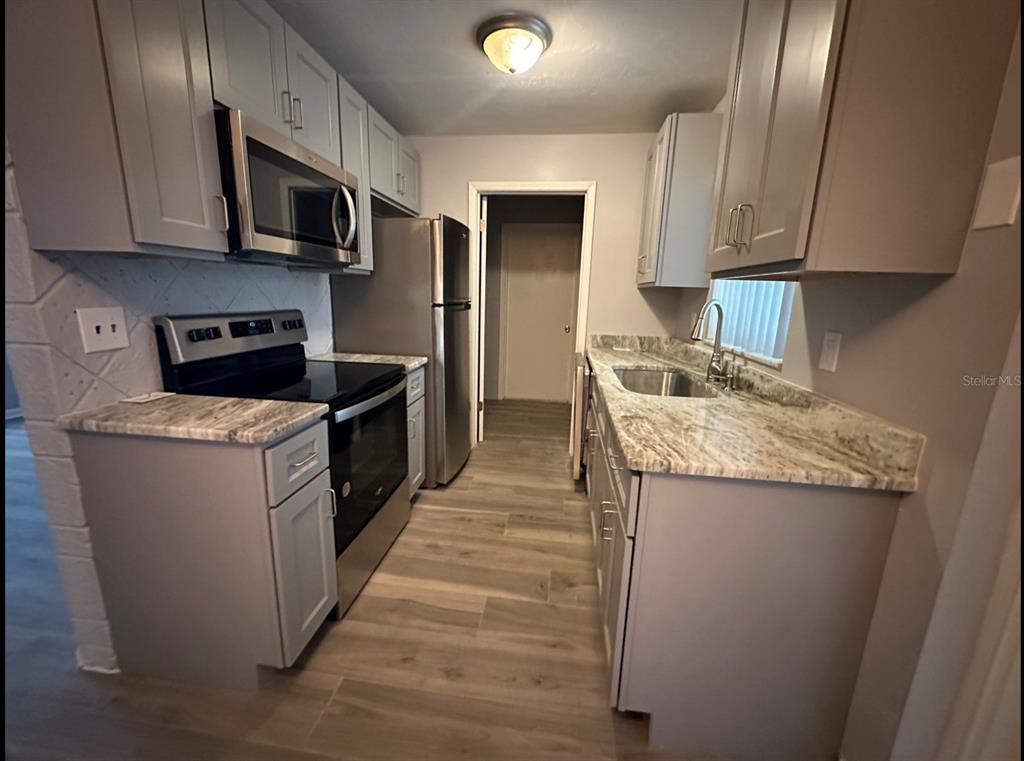 2906 Garden Road Eustis, FL 32726 - Photo 4 of 12 a kitchen with granite countertop a sink and a stove top oven