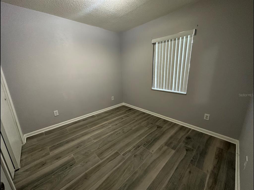2906 Garden Road Eustis, FL 32726 - Photo 6 of 12 a view of an empty room with wooden floor and a window