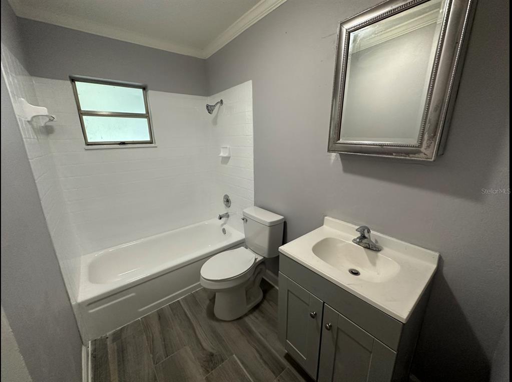 2906 Garden Road Eustis, FL 32726 - Photo 7 of 12 a bathroom with a sink mirror toilet and bathtub