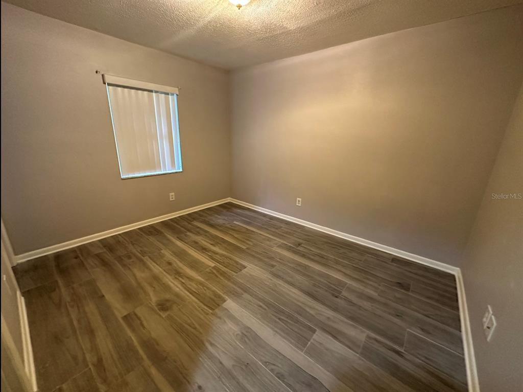 2906 Garden Road Eustis, FL 32726 - Photo 9 of 12 a view of an empty room with wooden floor and a window