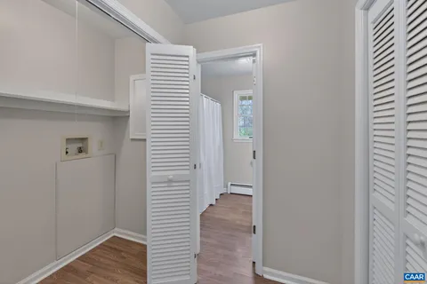 a view of a hallway with wooden floor and closet