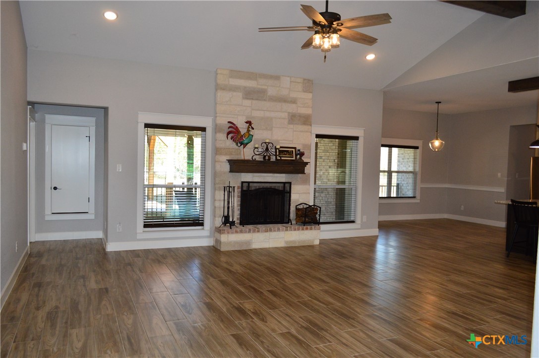 1026 County Road 3152 Kempner, TX 76539 - Photo 46 of 48 Open Floor Plan ** Family Room with Wood-Look Tile Flooring, Ceiling Fan, and Cozy Wood Burning Fireplace