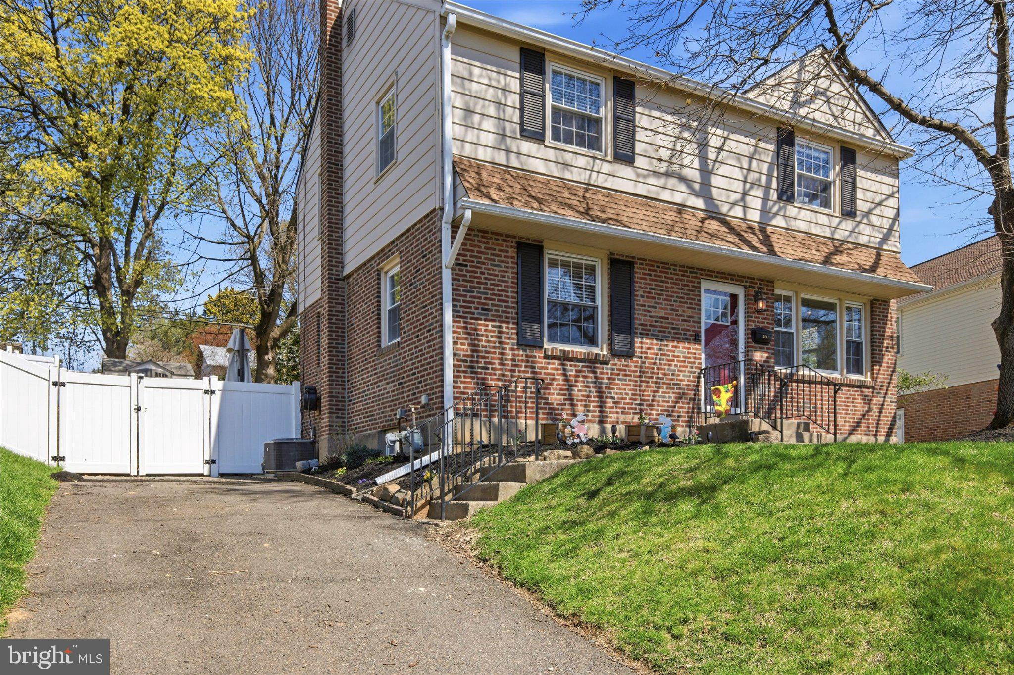 Charming brick home with lush greenery.