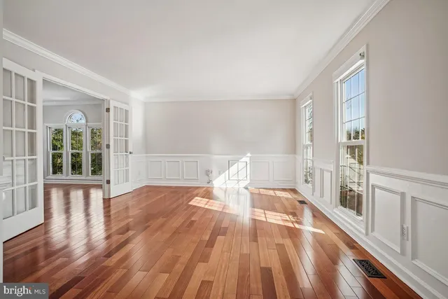 a living room with wooden floors and a large window
