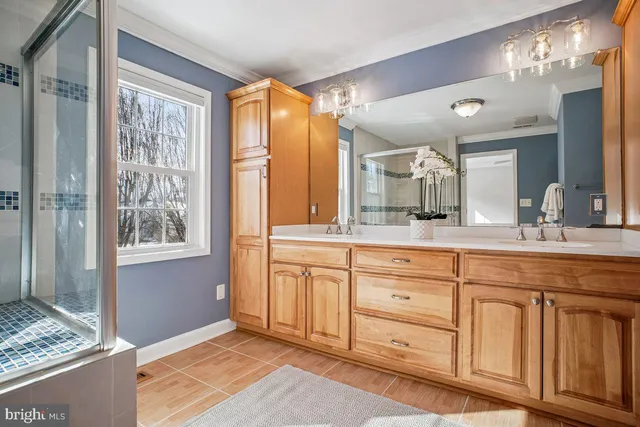 a spacious bathroom with a granite countertop sink mirror and a shower