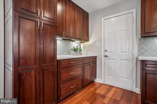 a view of a kitchen with wooden floor and cabinets