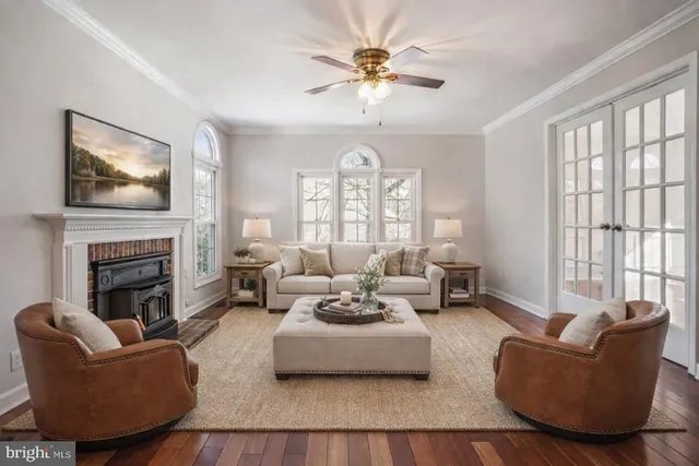 a living room with furniture fireplace and large windows