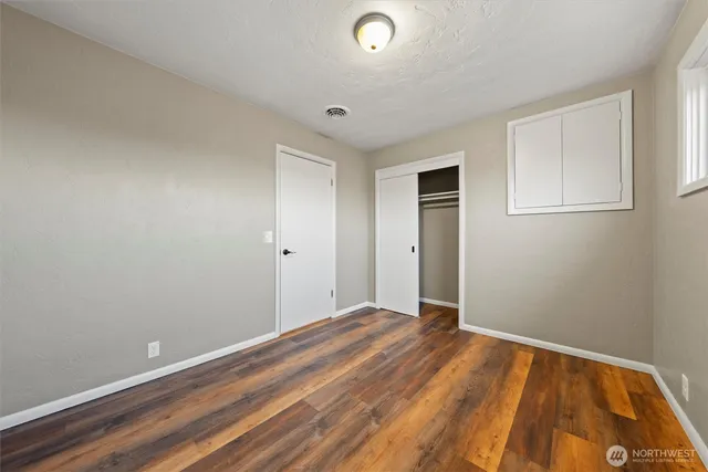 a view of an empty room with wooden floor