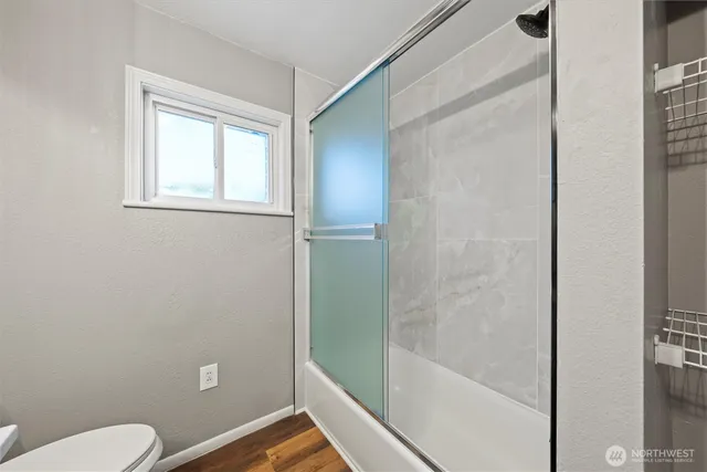 a bathroom with a toilet and a shower