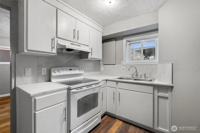 a kitchen with white cabinets and white appliances