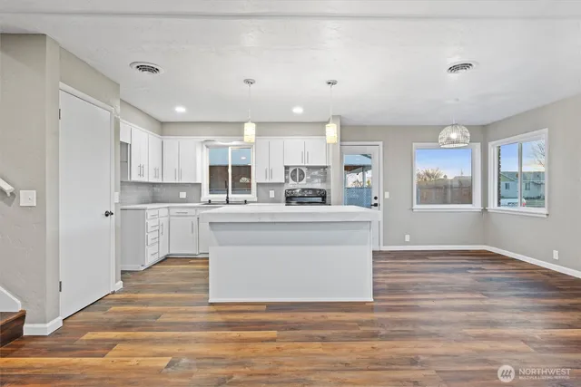 a view of kitchen with wooden floor and electronic appliances