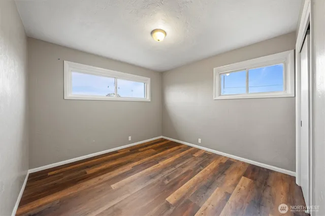 a view of room with window and wooden floor