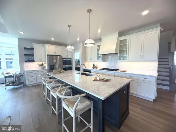 a kitchen with granite countertop a table chairs a sink dishwasher stove and cabinets with wooden floor