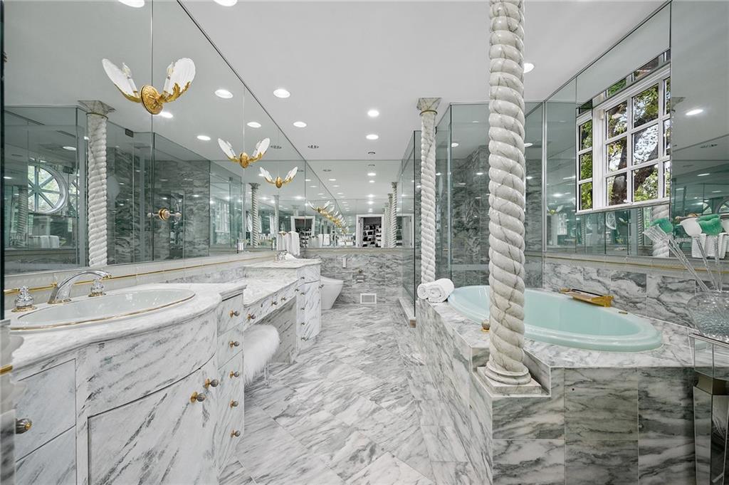 898 Persimmon Road Sewickley, PA 15143 - Photo 35 of 50 The spa-like primary bathroom with dual vanities and soaking tub all clad in marble is a true retreat.