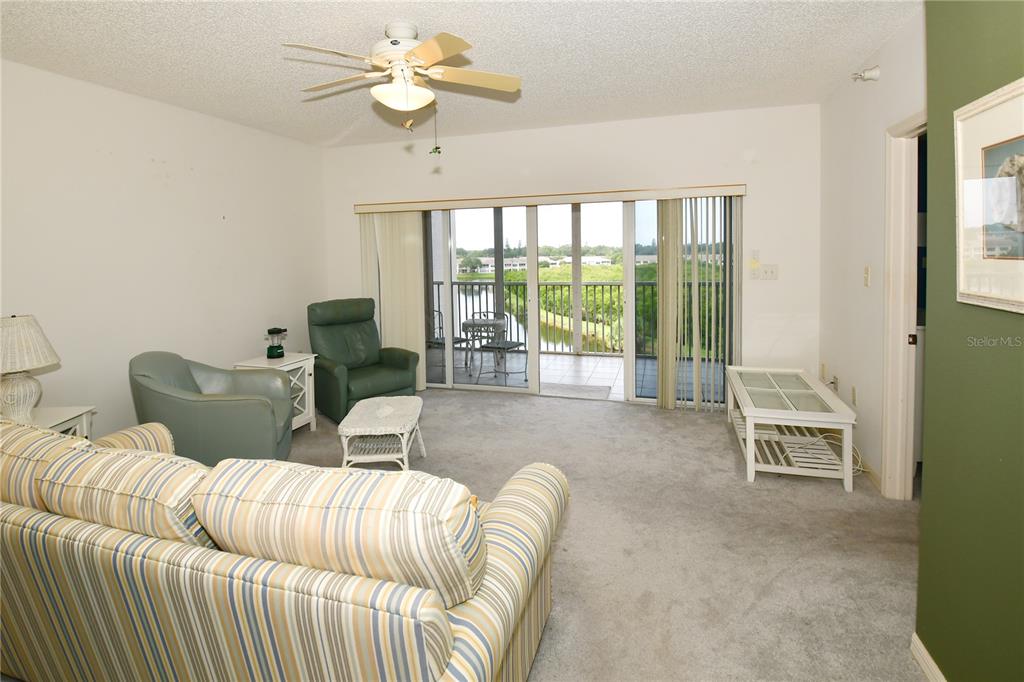 6450 Shoreline Drive, Unit 9405 St. Petersburg, FL 33708 - Photo 13 of 36 a living room with furniture and a floor to ceiling window