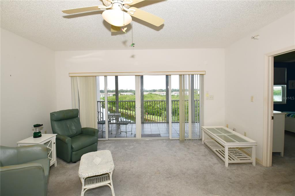 6450 Shoreline Drive, Unit 9405 St. Petersburg, FL 33708 - Photo 16 of 36 a living room with furniture and a floor to ceiling window