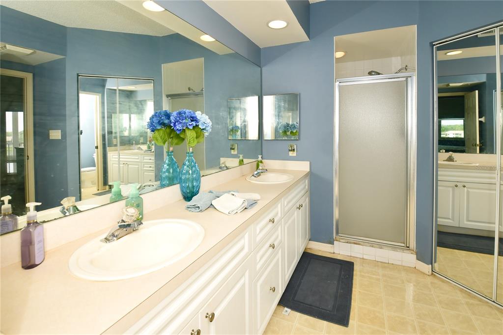 6450 Shoreline Drive, Unit 9405 St. Petersburg, FL 33708 - Photo 21 of 36 a bathroom with a double vanity sink mirror and shower